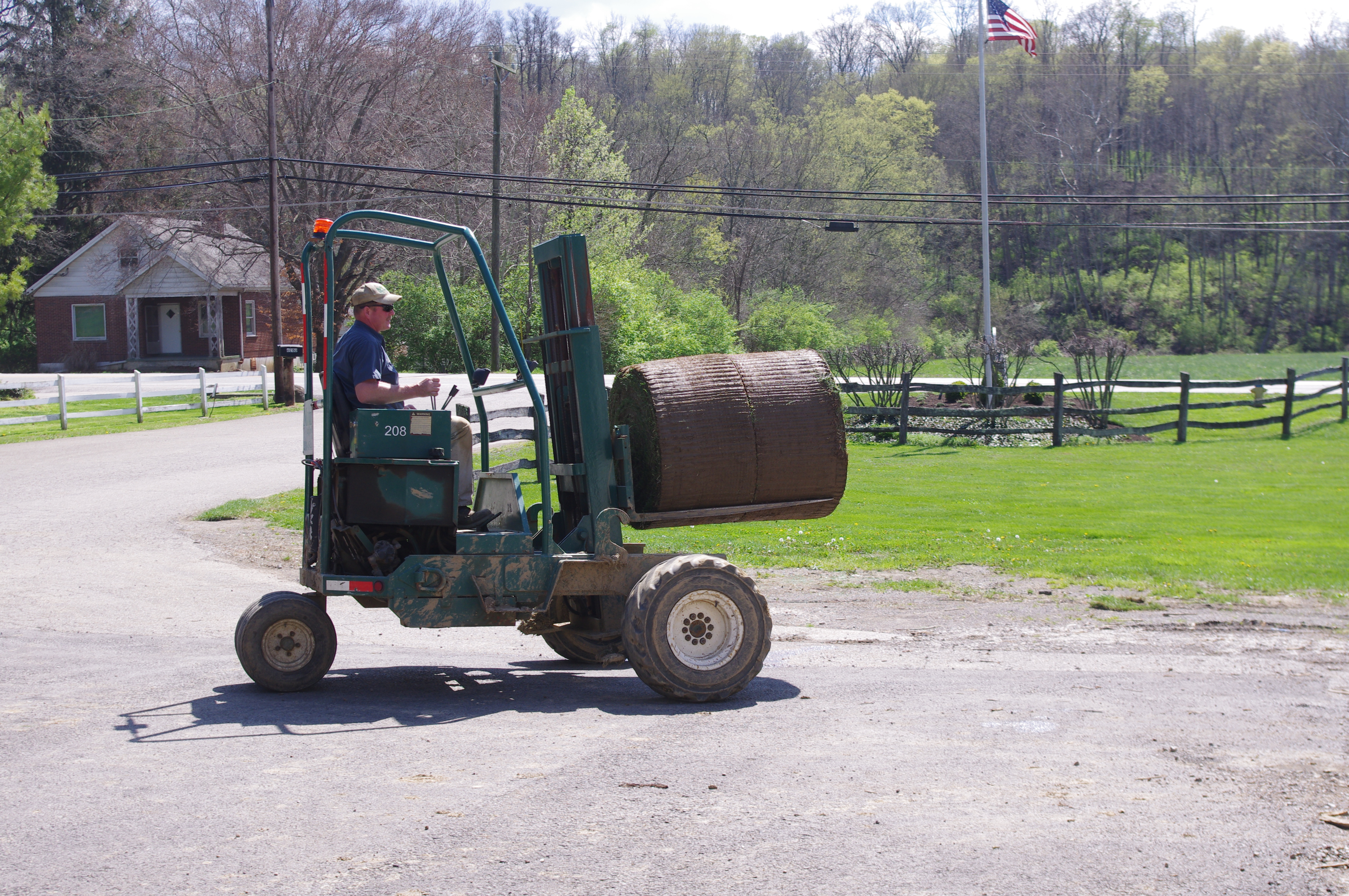 Motz team member transporting a large roll of sod at the farm